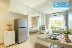 a kitchen and living room with a refrigerator and a table at The Sea Condo in Sam Roi Yot