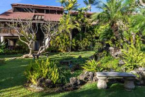 a park bench in front of a house at Maui Tranquility in Kihei