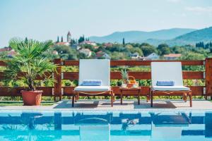 two chairs sitting next to a swimming pool at Villa Zen Imotski in Zmijavci
