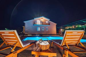 a basket and two chairs next to a swimming pool at Villa Zen Imotski in Zmijavci +81 photos