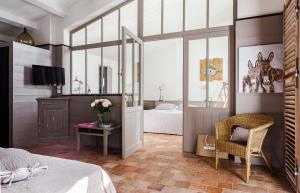 a bedroom with a bed and a table with a chair at Hotel Les Bois Flottais in Le Bois-Plage-en-Ré