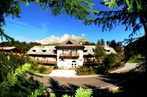 a large white house with mountains in the background at Residence Chris Appart in Carezza al Lago