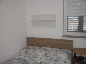 una piccola camera con letto e finestra di Apartman Ana a Omiš (Almissa)