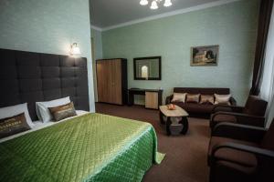 um quarto de hotel com uma cama e um sofá em Отель БЕССАРАБИЯ em Izmail