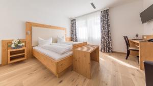 a bedroom with a bed and a desk with a computer at Heuboden Hotel Landhaus Blum in Umkirch