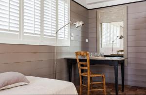 a bedroom with a desk and a chair and a mirror at Hotel Les Bois Flottais in Le Bois-Plage-en-Ré