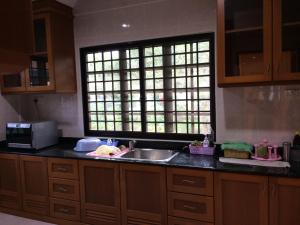 a kitchen with a sink and a window at Golden Swan Sibu Homestay in Sibu