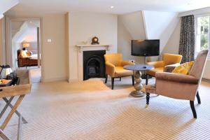 a living room filled with furniture and a tv at The Crown Manor House Hotel in Lyndhurst
