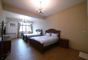 una camera da letto con due letti e un lampadario di Chi Chi B&B a Tainan