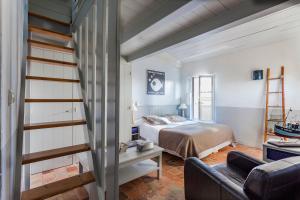 a bedroom with a bed and a staircase in a room at Hotel Les Bois Flottais in Le Bois-Plage-en-Ré