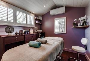 a bedroom with a bed in a room with purple walls at Hotel Les Bois Flottais in Le Bois-Plage-en-Ré