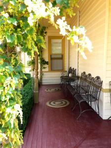 a porch with chairs and a table on a house at Goldenray in Castlemaine