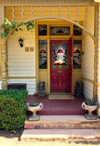 a red front door of a house with sidelights at Goldenray in Castlemaine