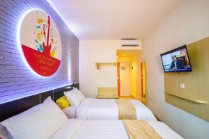 pokój hotelowy z dwoma łóżkami i telewizorem w obiekcie Front One Inn Muntilan w mieście Muntilan