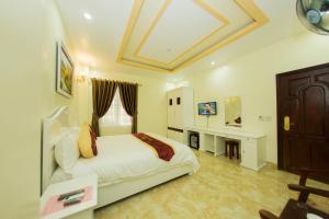 a bedroom with a bed and a desk in it at Mai Anh Hotel in Lao Cai