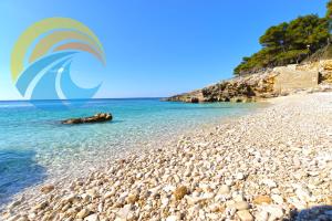 a beach with a rocky shore and the ocean at Apartments Ivanka 1056 in Pula