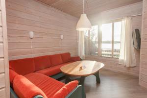 a living room with a red couch and a table at Hamre Familiecamping in Kristiansand +9 photos