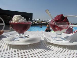 zwei Gläser Eis und Erdbeeren auf dem Tisch in der Unterkunft Santa Tecla Palace in Acireale