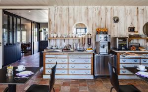 a kitchen with wooden walls and a table and chairs at Hotel Les Bois Flottais in Le Bois-Plage-en-Ré