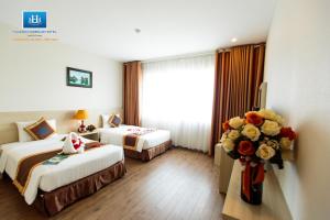 Postel nebo postele na pokoji v ubytování Halong Harbour Hotel