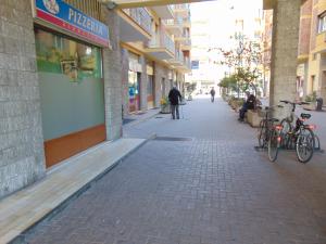 una calle con bicicletas estacionadas en el lateral de un edificio en Mr Jackpot2, en Canelli
