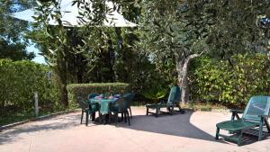een tafel en stoelen op een patio met bomen bij Casa Vacanze La Caprignola in Buccino