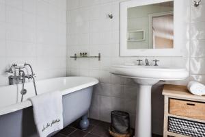 a bathroom with a tub and a sink and a bath tub at Hotel Les Bois Flottais in Le Bois-Plage-en-Ré