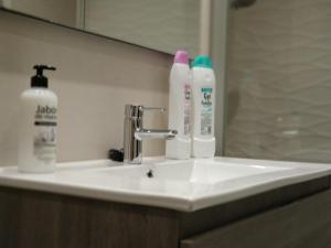 a bathroom sink with two bottles ofodorizers on it at San Anton Centro Apartment in Logroño