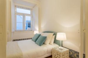 una piccola camera con un letto e una finestra di Chiado Apartment - Holiday Rental in Lisbon a Lisbona