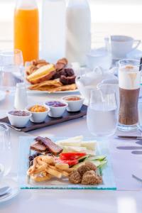 a table with plates of food and glasses of water at Horizon Blu Boutique Hotel in Kalamata