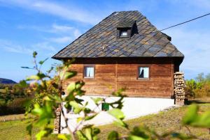 a wooden house with a slate roof at Cabin Menka in Sirogojno