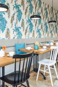 a dining room with tables and chairs and a wall with blue flowers at Strandhaus Ahrenshoop in Ahrenshoop +44 photos