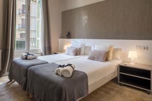 two beds in a hotel room with towels on them at Habitat Apartments Garden View in Barcelona