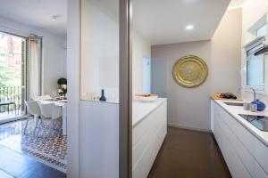 a kitchen with white cabinets and a dining room at Habitat Apartments Garden View in Barcelona