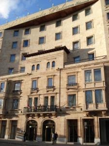 um grande edifício com pessoas de pé na frente dele em Hotel Alameda Palace em Salamanca