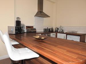 a kitchen with a wooden table and white chairs at Parks Nest 1 in Hull