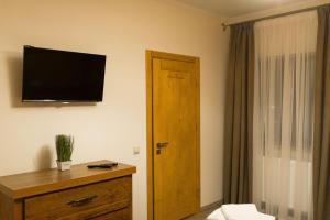a hotel room with a television on the wall and a door at Chalet Residence in Tatariv