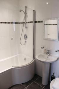 a white bathroom with a tub and a sink at Princes Dock Chambers 3 in Hull