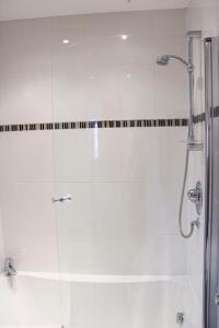 a bathroom with a shower with a glass door at Princes Dock Chambers 3 in Hull