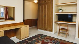 a living room with a tv and a chair in a room at Hotel Piñupe in Lekeitio