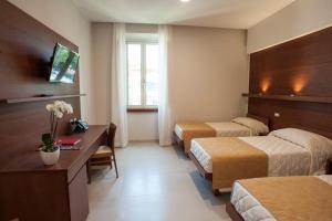 ローマにあるVilla Angelinaのベッド2台とデスクが備わるホテルルームです。
