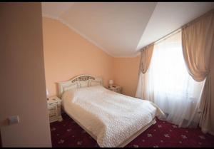 a bedroom with a white bed and a window at Amfora Hotel in Nakonechnoye