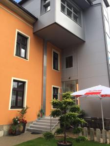 an orange and white building with a tree and an umbrella at Hotel Bellini in Leoben