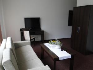 a living room with a couch and a coffee table at Hotel Cynamon in Tokarnia