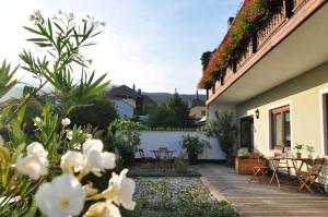 a garden with tables and chairs on a house at Gästehaus Hofer in Gumpoldskirchen