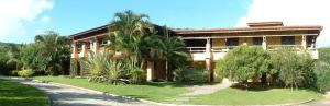 a building with palm trees in front of it at Palmas Hotel & Spa in Governador Celso Ramos