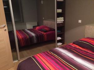 a bedroom with a mirror next to a bed at L'Oddo de Gissey in Le Puy en Velay