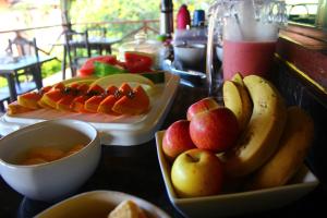 una mesa cubierta con platos de fruta en una mesa en Pousada Luar do Cipó, en Serra do Cipo
