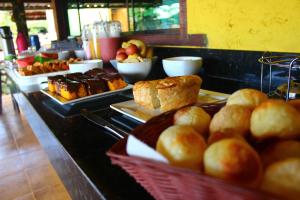 un buffet con pan, bollería y otros productos alimenticios en Pousada Luar do Cipó, en Serra do Cipo