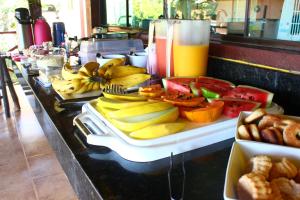 a buffet with bananas and fruit on a table at Pousada Luar do Cipó in Serra do Cipo